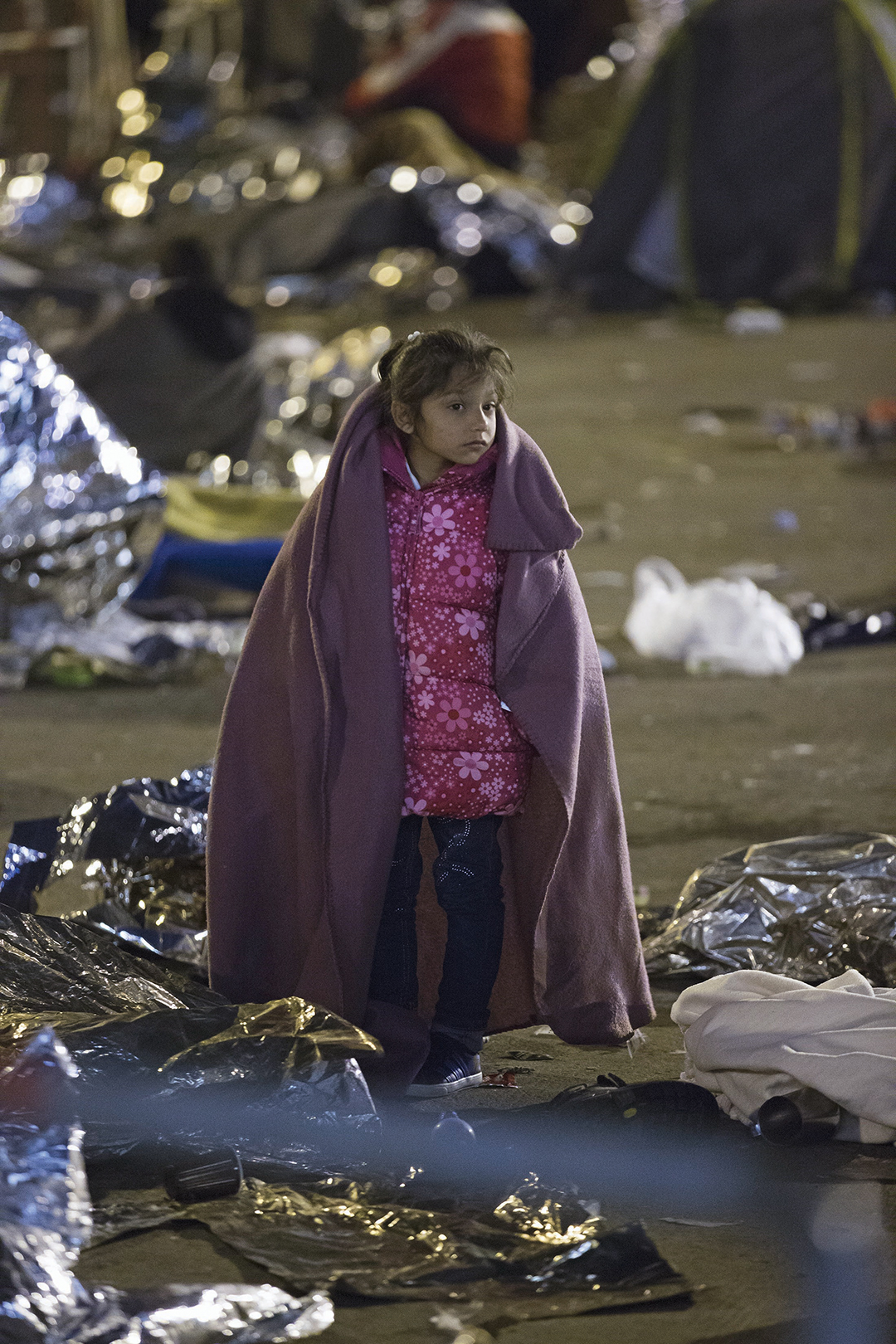 Ребенок-беженец идет через лагерь на словено-австрийской границе в октябре 2015 г. После регистрации мигрантов Словения передает их в Австрию, где они продолжают свою путь в Германию и другие страны Западной Европы. epa